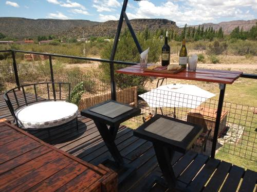 格兰德山谷Balcon al Valle Grande, San Rafael Mendoza的一个带桌子和两把椅子的甲板和一张野餐桌