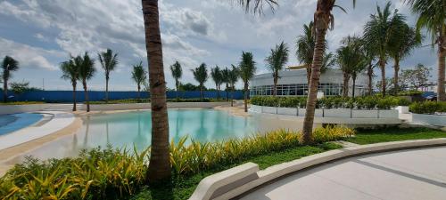 圣费尔南多Azure North San Fernando Pampanga的一座楼前种有棕榈树的游泳池