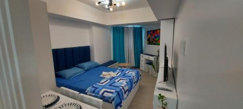 圣费尔南多Azure North San Fernando Pampanga的一间卧室配有蓝色的床和电视