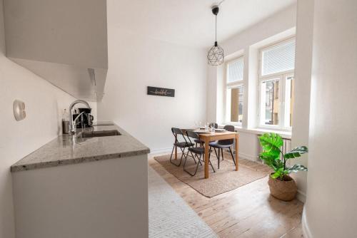 赫尔辛基2ndhomes Mikonkatu Apartment 4的厨房以及带桌椅的用餐室。