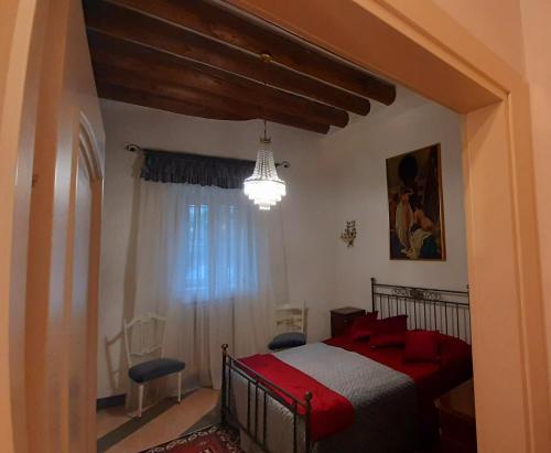 Rodengo SaianoCasa Giulia的一间卧室配有一张红色的床和吊灯。
