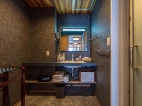 热海热海温泉山木日式旅馆的一间带水槽和镜子的浴室