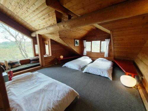 神户RENEST的小木屋内一间卧室,配有两张床