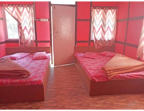 PedongRishi River Cottage, West Bengal的红色墙壁客房的两张床