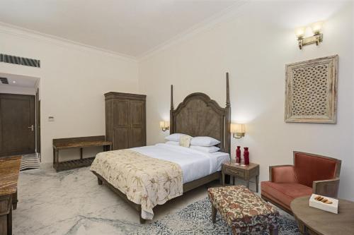 乌代浦Fateh Vilas by Fateh Collection的一间卧室配有一张床、一把椅子和一张沙发