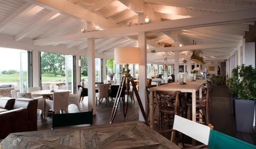 AtzenbruggHotel Diamond Country Club的用餐室设有桌椅和窗户。
