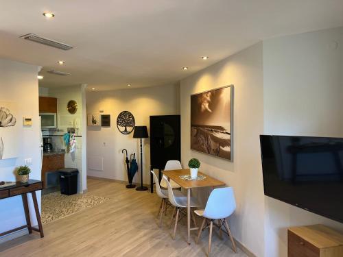 拉拉古纳La Laguna Luxe Apartment的客厅配有桌椅和电视。