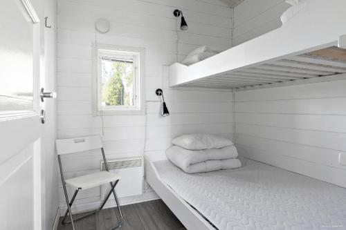 GunnarskärFirst Camp Mörudden-Karlstad的白色的小房间,配有床和椅子