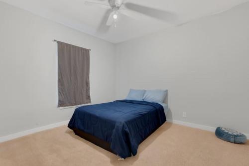 达拉斯Near Bishop Arts District Spacious 3 Bedroom Home!的一间白色客房内的蓝色床卧室