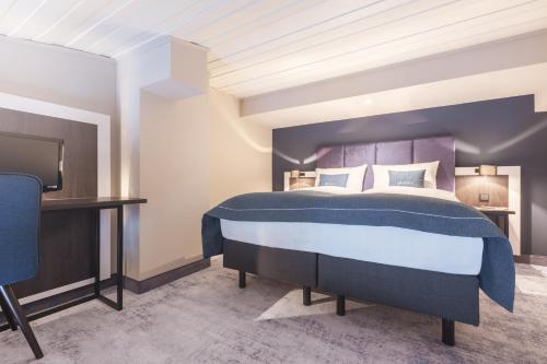 埃尔姆斯霍恩Select Hotel Elmshorn的一间卧室配有一张特大号床和一台电视
