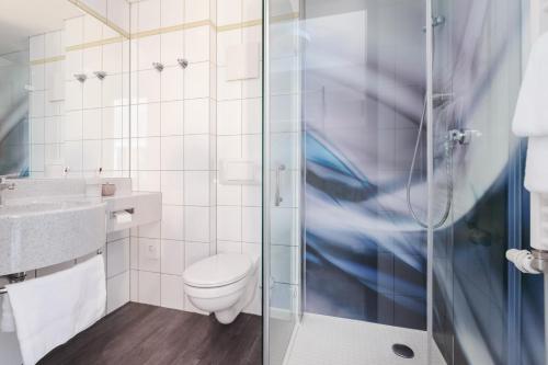 埃尔姆斯霍恩Select Hotel Elmshorn的一间带卫生间和玻璃淋浴间的浴室