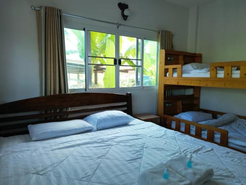 清莱Open Kitchen的一间卧室设有两张双层床和一扇窗户。