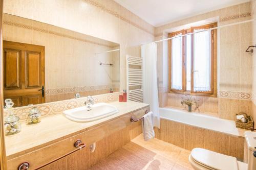 奥利特Ronda del Castillo的一间带水槽、浴缸和镜子的浴室