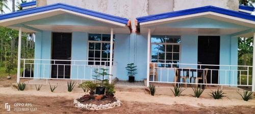 MatabaApar Beach Resort的一个小蓝色房子,设有门廊