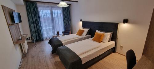 凯斯特海伊巴克斯酒店的配有橙色枕头的床的酒店客房
