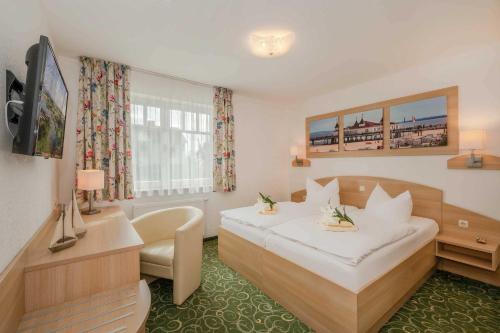 Usedom TownGasthaus Natzke的一间酒店客房,配有一张白色的床和一张书桌