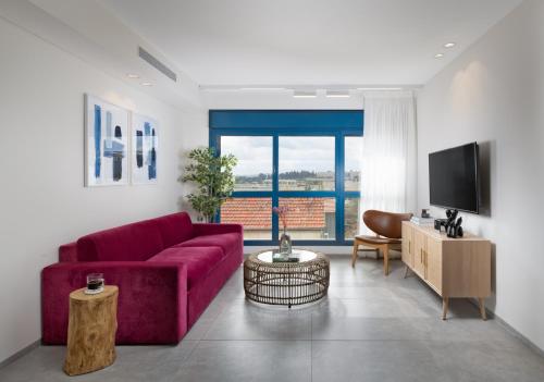 耶路撒冷AMALON Boutique Apartments的客厅配有红色沙发和电视