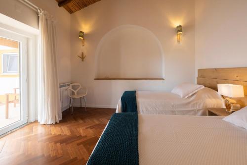 塞尔帕Quinta Marugo Retreats的一间卧室设有两张床和大窗户