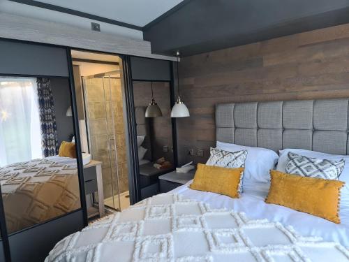 马根波思Mawgan Pads Lazy Days Lodge的卧室配有一张带黄色枕头的大型白色床。