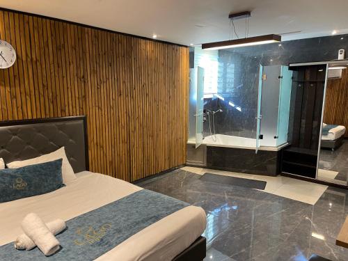 耶路撒冷Lago Suites Hotel的一间卧室设有一张床和一个玻璃淋浴间