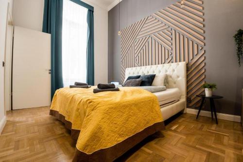 布达佩斯Deluxe Quentin Home next to the Fashion Street的一间卧室配有一张床和一张带黄色毯子的沙发