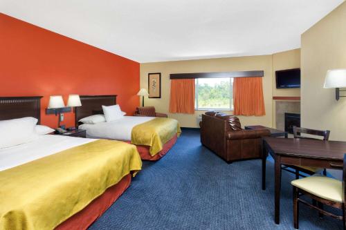 维代利亚AmericInn by Wyndham Vidalia的酒店客房配有两张床和一张书桌