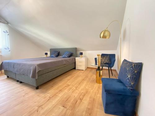 HimmelkronFerienwohnung Fuchs的一间卧室配有一张床和一张蓝色椅子