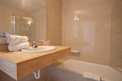 萨科马多拉塔海滩公寓式酒店的浴室配有盥洗盆和浴缸。