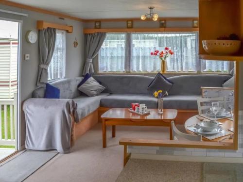 伯克顿Norfolk Poppy Caravan - Sleeps 4 - WiFi and Sky TV Included的客厅配有沙发和桌子