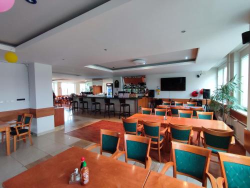 布拉迪斯拉发HOTEL JURKI Dom的一间带桌椅的餐厅和一间酒吧