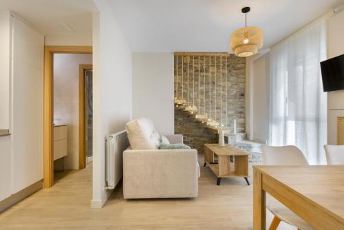 哈卡Apartamentos La muralla de Jaca的客厅配有椅子和桌子