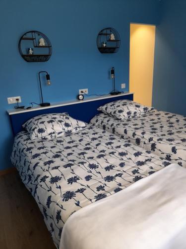 孔特雷克塞维尔Au fil du bois的一间卧室设有一张床和蓝色的墙壁