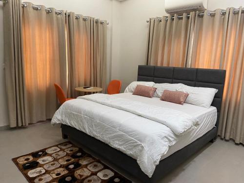 阿克拉Queens View Apartment的一间卧室配有大床和橙色椅子