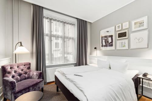 哥本哈根亚瑟库隆酒店的配有一张床和一把椅子的酒店客房