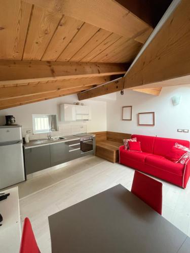 阿科La Casa di Giò的一间带红色沙发的客厅和一间厨房