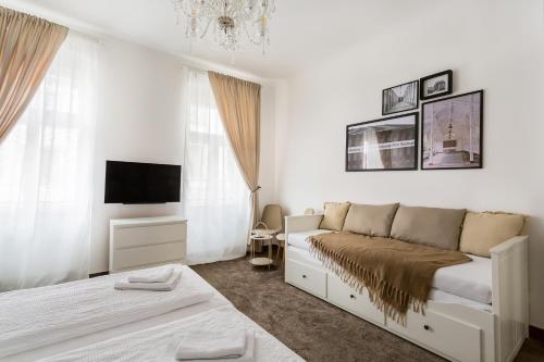 卡罗维发利Apartmá Zeyer 1887的一间白色卧室,配有床和电视