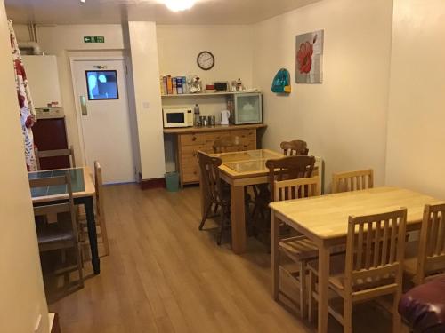 哈特尔普尔Sea View Guest House的厨房以及带木桌和椅子的用餐室。