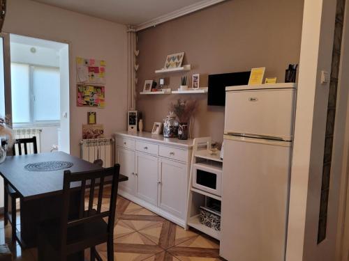 康斯坦察Relax Apartament的厨房配有白色冰箱和桌子