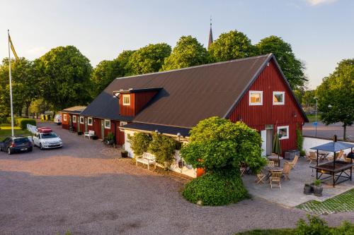 哈尔姆斯塔德Halmstad Gårdshotell的享有红色谷仓空中景色,外面设有停车场