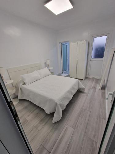 大加那利岛拉斯帕尔马斯GUANARTEME 33的一间白色卧室,配有床和2个窗户