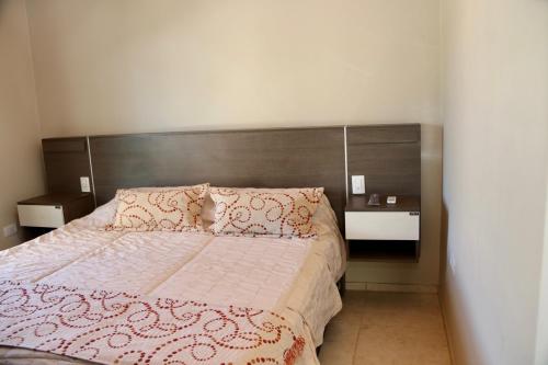 Vista FloresComplejo Turístico Natuel的一间卧室配有一张带木制床头板的床