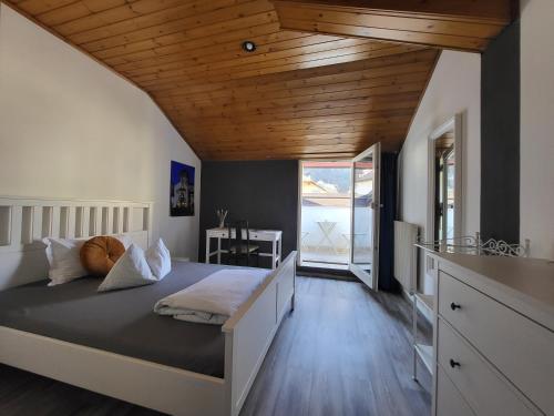 萨洛尔诺Albergo Gasthof Salurn的一间卧室设有一张带木制天花板的大床
