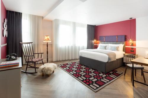 卡迪夫加的夫靛蓝酒店的卧室里设有床,卧室里还养着狗