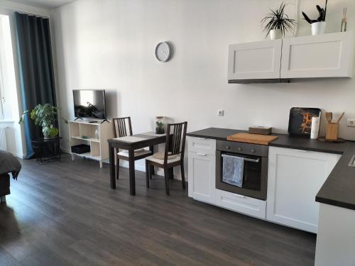 哈姆Diamera Appartments Zentral und Modern的厨房配有白色橱柜和桌椅