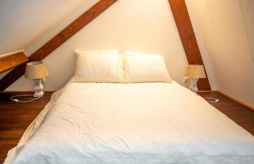 ArriënAtelier / Guesthouse Arriën - De Studio van Slim的一张带白色床单的床和两盏灯