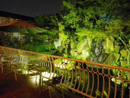 泉佐野海鸥酒店的一组桌椅和一把伞