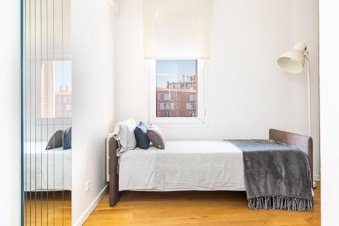 巴塞罗那Idyllic apartment in BCN beach的白色的卧室设有床和窗户
