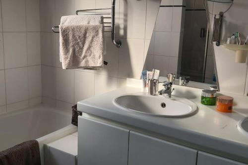 霍恩House close to beach and the city of Hoorn的白色的浴室设有水槽和浴缸。