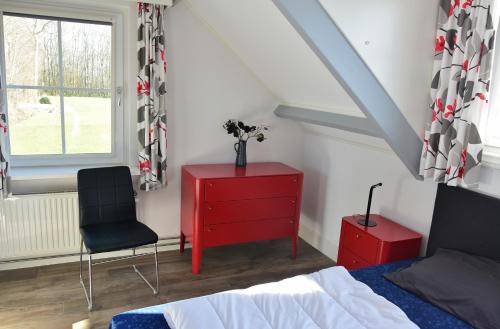 东卡佩勒Woning zeldenrust 6的一间卧室配有红色梳妆台和红色椅子