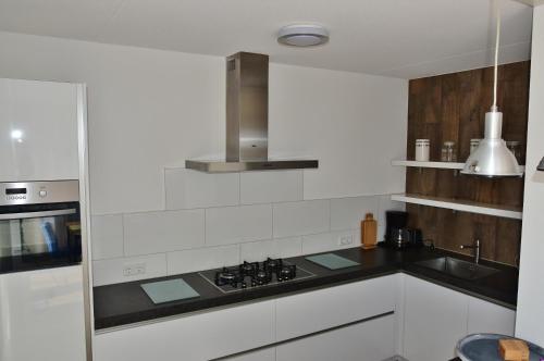东卡佩勒Woning zeldenrust 6的白色的厨房配有炉灶和水槽